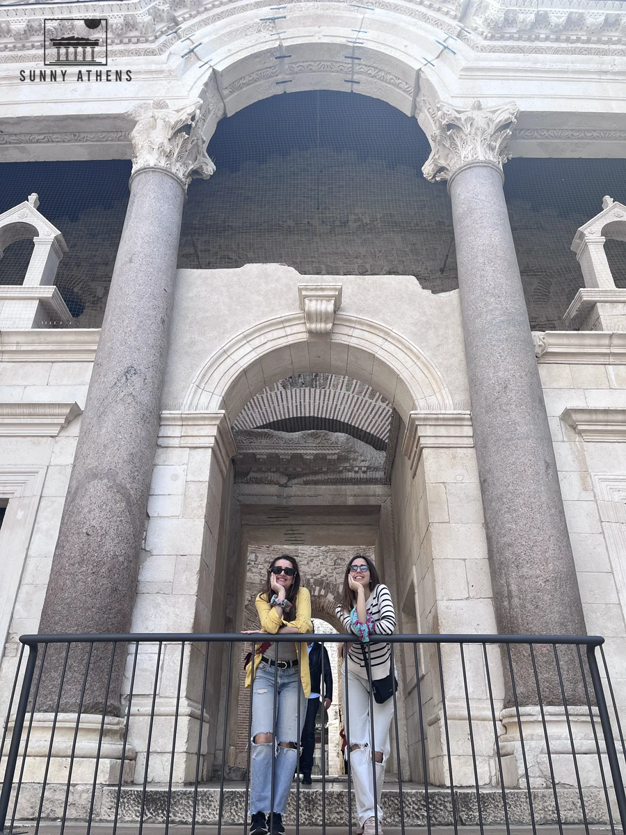 Chrysavgi smiling in front of the monumental stone archway and ancient columns inside Diocletian's Palace in Split