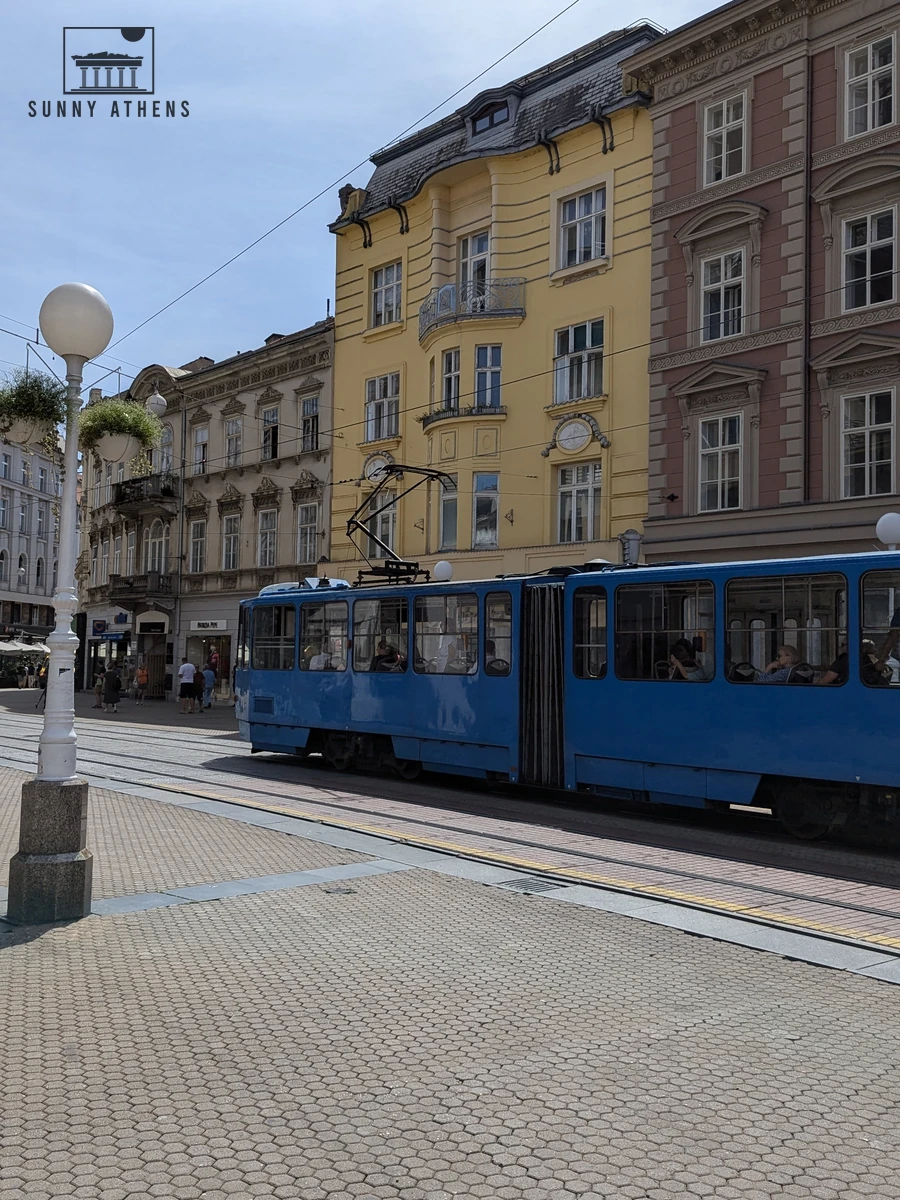 Zagreb blue city tram turning onto the central pedestrian square in front of historic buildings