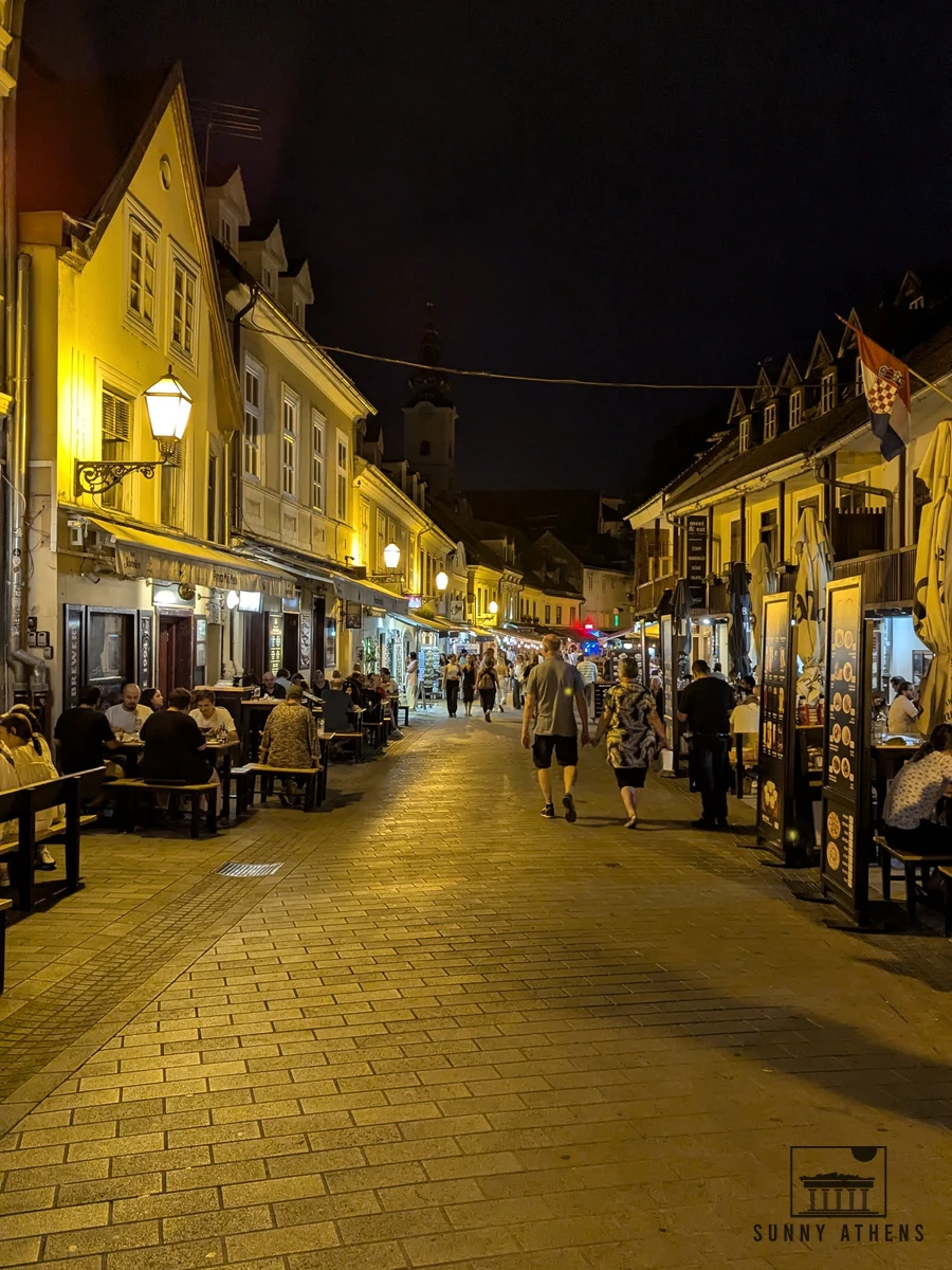 Pedestrian Tkalciceva Street lit by warm street lanterns with outdoor café tables in evening Zagreb