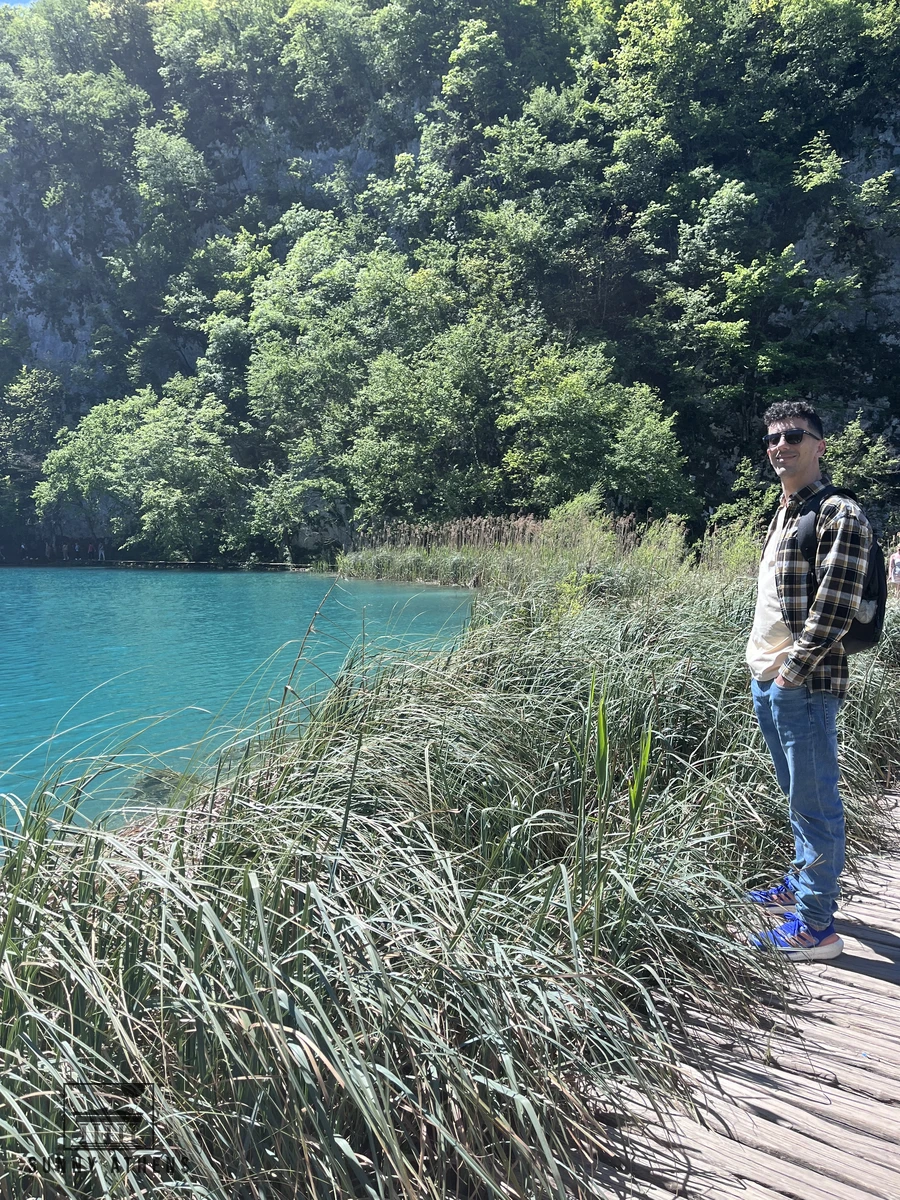 Walking along the wooden boardwalk path next to the turquoise lake in Plitvice Lakes National Park