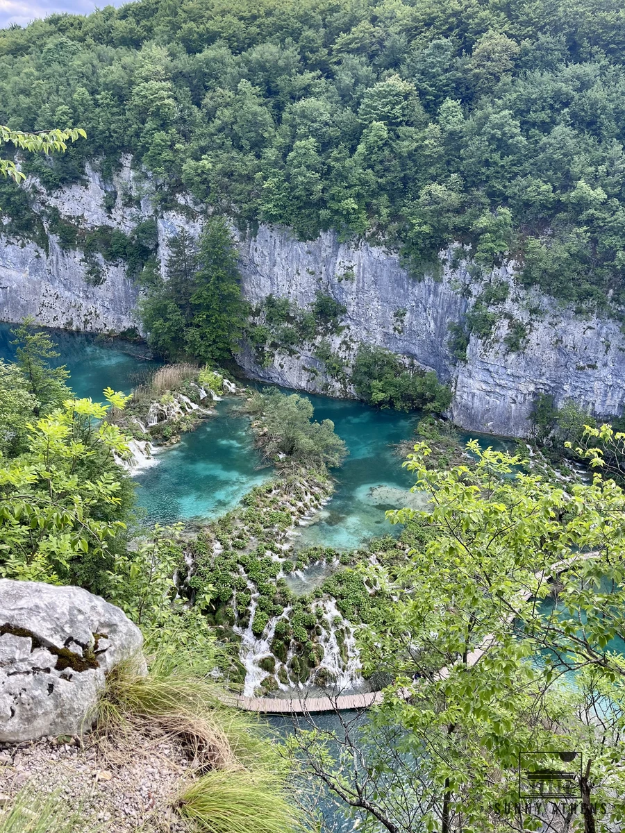 Aerial view looking down at stepped travertine cascades and wooden boardwalks